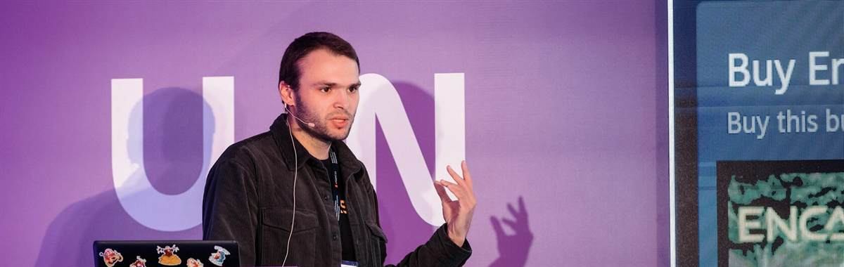 Artem Korovkin speaking on stage at a game industry conference